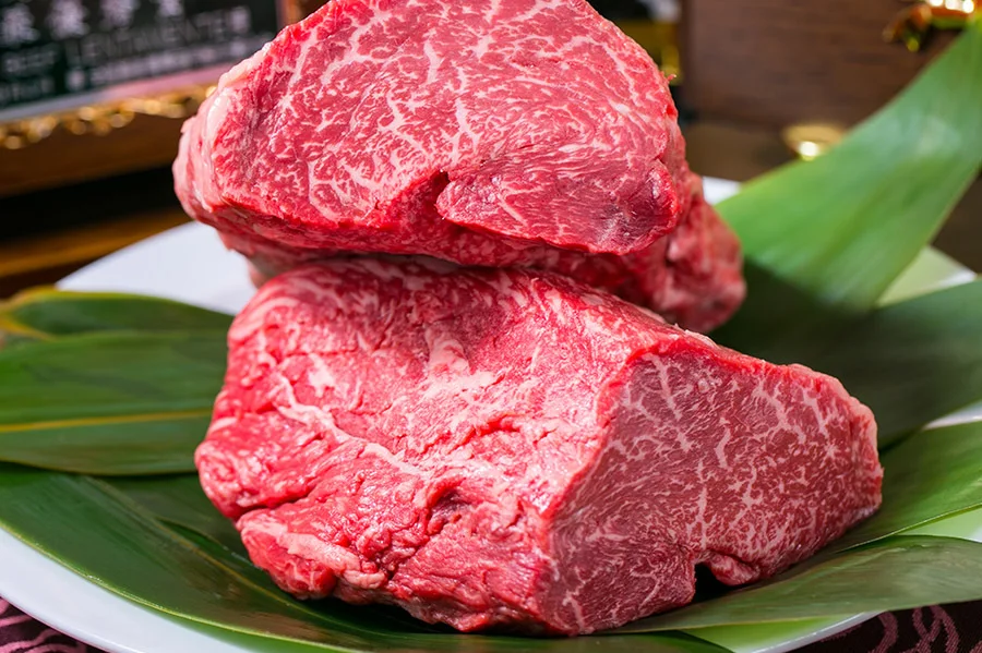 笹の上に置いた神戸牛の塊肉。霜降りが細かく入る