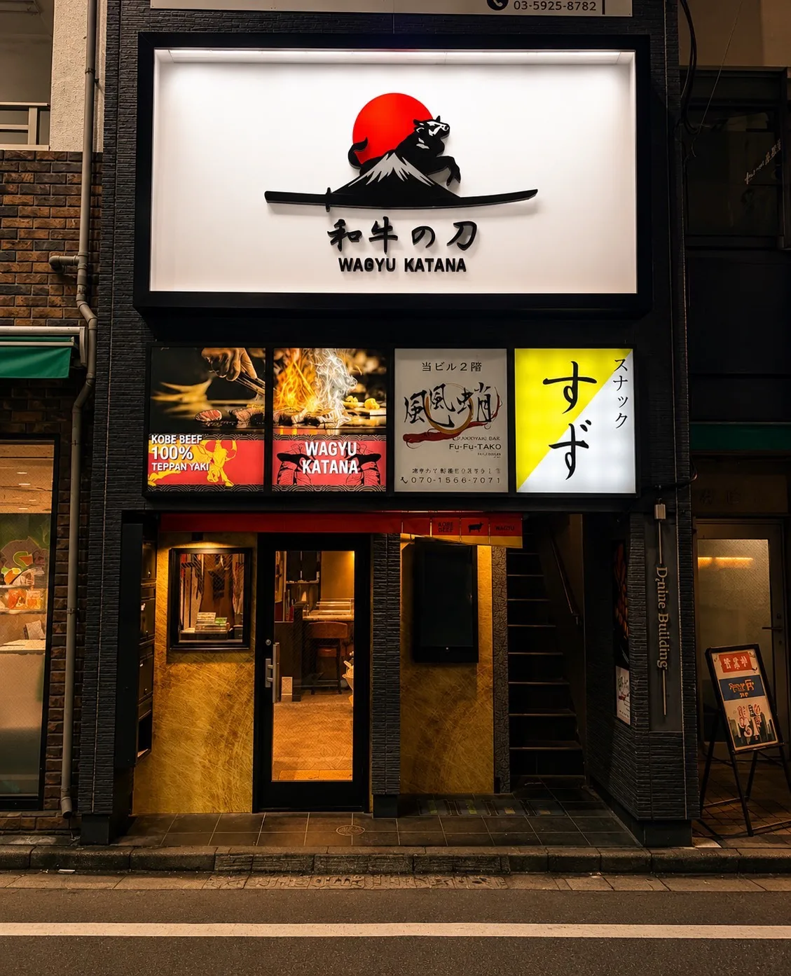 歌舞伎町花園神社店の店頭。日輪と富士に牛をあしらった「和牛の刀」の看板が灯る夜の外観