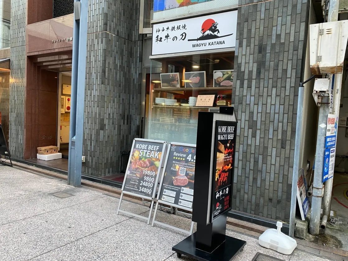 Menu boards set out in the passage beside the building