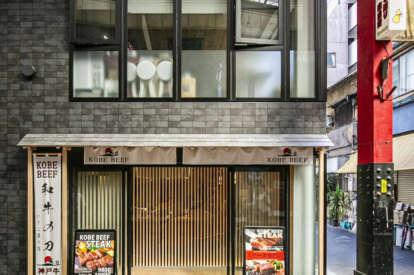 The ground-floor frontage, fitted with a wooden lattice and noren curtain