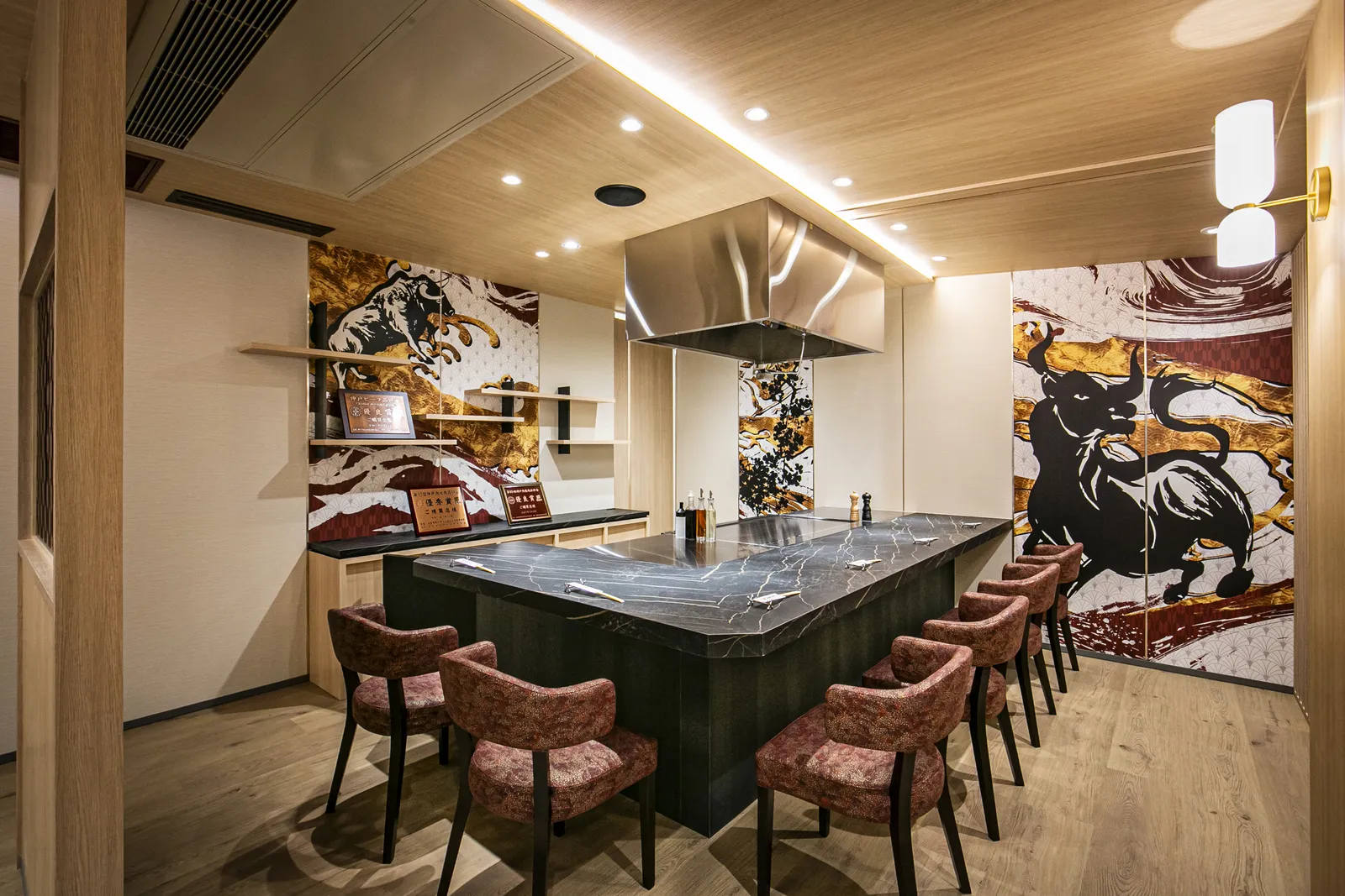 Teppan counter seating beside a mural of a bull and Mt. Fuji