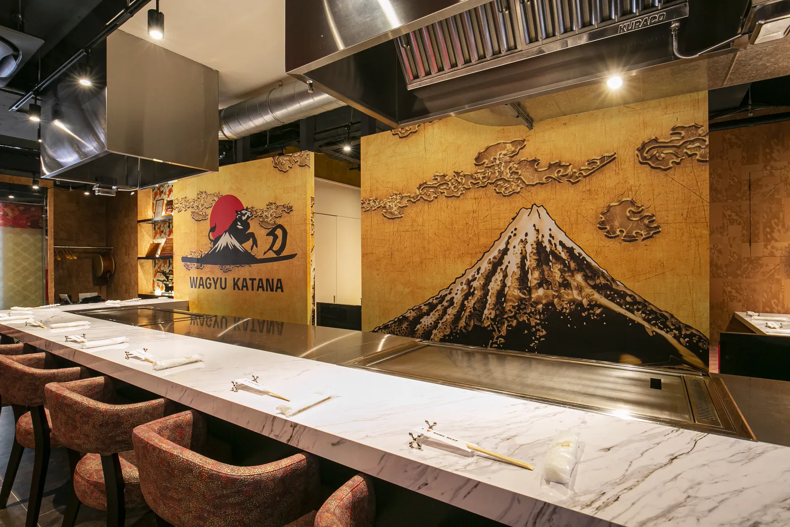 Teppan counter seating set against a painted mural of Mt. Fuji